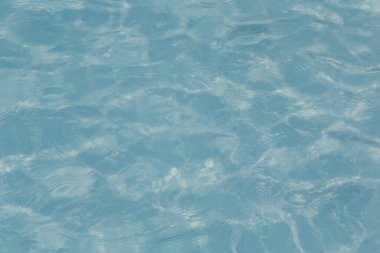 Güneşi yansıtan mavi havuz suyu