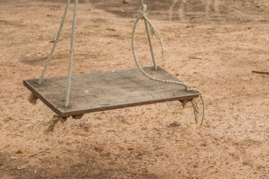 Arka bahçede ipte eski ahşap salıncak