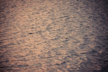 Güzel su dalgası desenli günbatımı. Güzel harmonik yapısı ve yansımaları var.