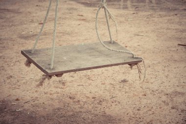 Arka bahçede ipte eski ahşap salıncak