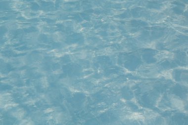 Güneşi yansıtan mavi havuz suyu