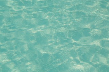 Güneşi yansıtan mavi havuz suyu