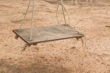 Arka bahçede ipte eski ahşap salıncak