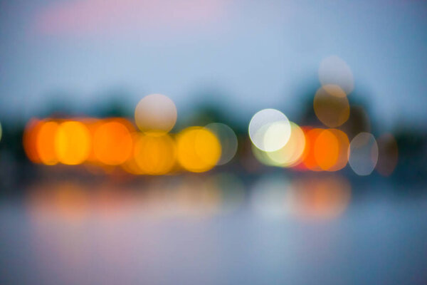 Beautiful blurred city lights with bokeh effect reflected on water background