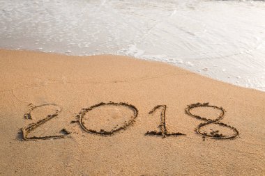 2018 plaj arka planındaki kuma yazılmış bir mesaj.