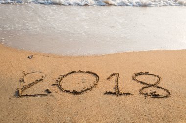 2018 plaj arka planındaki kuma yazılmış bir mesaj.