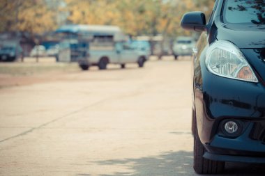 Otoparkın arka planındaki siyah otoparkın yarı önü.