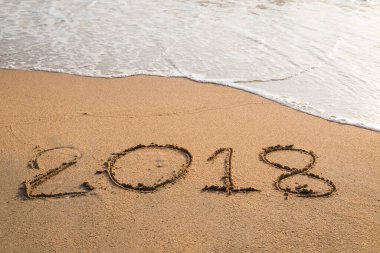 2018 plaj arka planındaki kuma yazılmış bir mesaj.