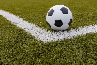 Futbol topu, futbol stadyumunda beyaz çizgili suni çimlerde futbol.