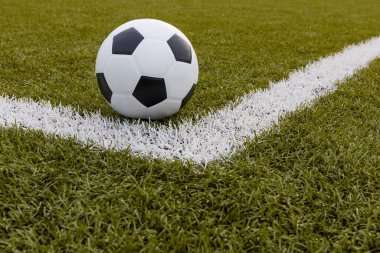 Futbol topu, futbol stadyumunda beyaz çizgili suni çimlerde futbol.