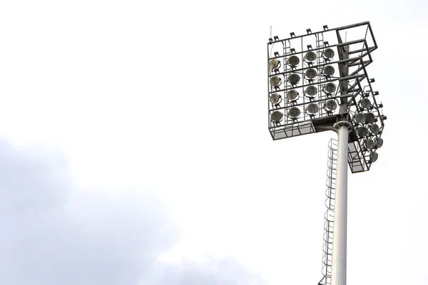 Spotlight on lighting tower of stadium background