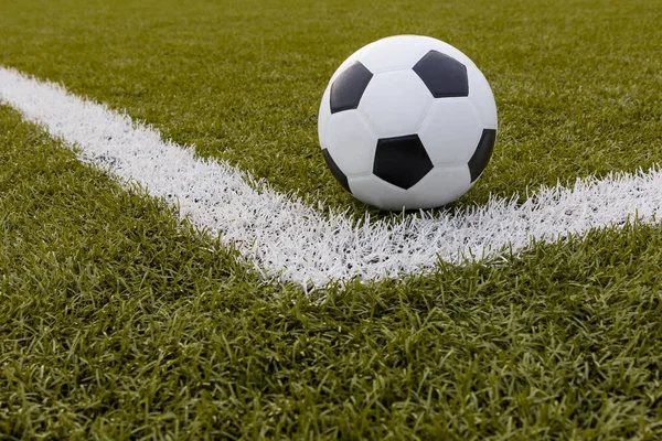 Futbol topu, futbol stadyumunda beyaz çizgili suni çimlerde futbol.