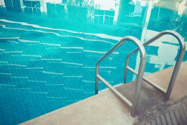Mavi yüzme havuzu arka planında parmaklık merdiveni
