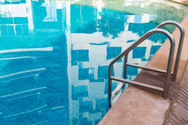 Mavi yüzme havuzu arka planında parmaklık merdiveni