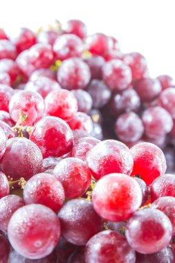 Beyaz zemin üzerinde su damlası olan taze kırmızı üzüm.