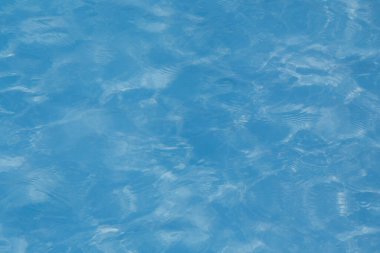 Güneşi yansıtan mavi havuz suyu