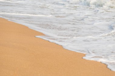 Kumsalın arka planında yumuşak köpük dalgası ve deniz