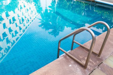 Mavi yüzme havuzu arka planında parmaklık merdiveni