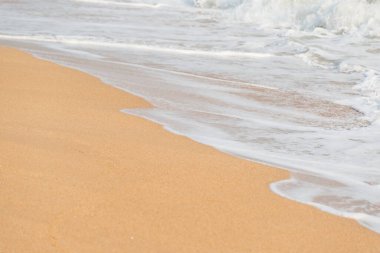 Kumsalın arka planında yumuşak köpük dalgası ve deniz