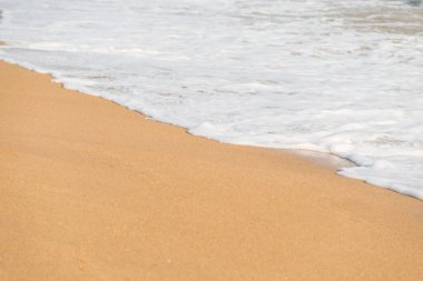 Kumsalın arka planında yumuşak köpük dalgası ve deniz