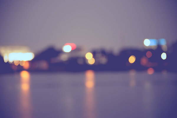 Beautiful blurred city lights with bokeh effect reflected on water background