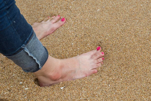 Weibliche Füße Mit Roter Pediküre Tragen Blauen Jeansständer Strand — Stockfoto
