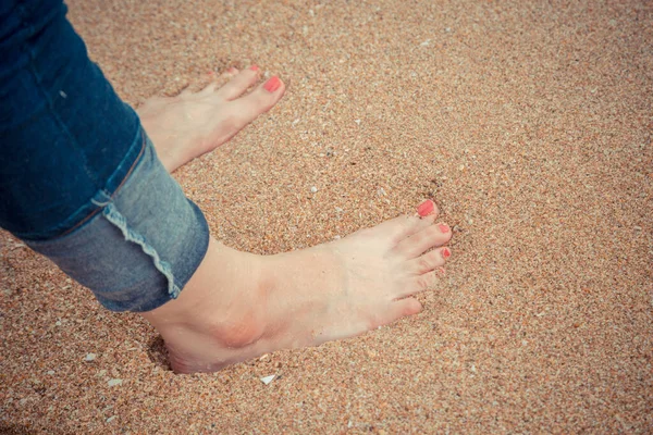 Kvinnliga Fötter Med Röd Pedikyr Bära Blå Jean Stå Stranden — Stockfoto