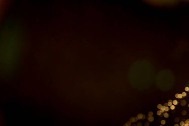 Altın rengi bulanık bokeh siyah arkaplana odaklandı