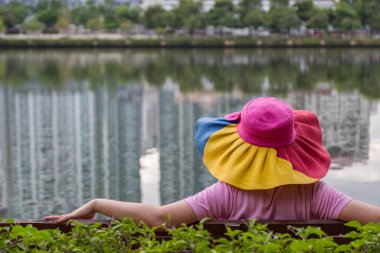 Şapka takan kadınlar parkta oturur ve dinlenirler.