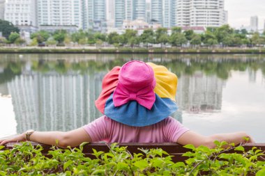Şapka takan kadınlar parkta oturur ve dinlenirler.