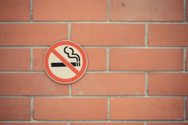 Kırmızı tuğla arkaplanda sigara içilmiyor