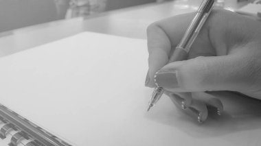 Boş belgelerin arkaplanını kalemle kapatan kadın elleri