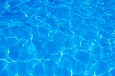 Işık yüzme havuzundaki suda maviyi yansıtıyor. Taze ve canlı görünüyor. Duvar kağıdı arka planı olarak kullanılabilir.