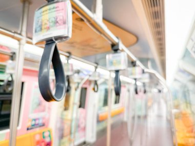 Parlak sarı koltukları ve paslanmaz çelik direkleriyle metro içi boş bir metro manzarası. Modern tren vagonu iyi ışıklandırılmış, üst kulpları ve pürüzsüz, temiz zeminleri var, hareket halindeki toplu taşımayı öneriyor..