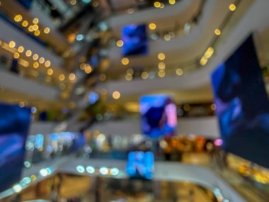 Hareketli bir alışveriş merkezinin bulanık görüntüsü modern bir perakende satış ortamının canlı atmosferini yakalıyor. İnsanlar alışveriş yaparken görülüyor.