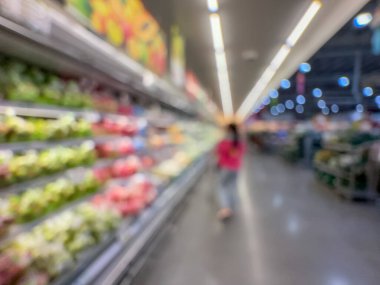 Raflarda çeşitli taze meyve ve sebzelerin sergilendiği bir market üretim bölümünün bulanık görüntüsü. Resim ürünün canlı renklerini ve dokularını yakalar