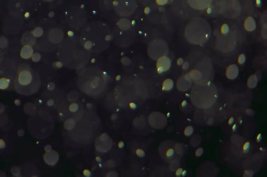 Koyu bir arkaplanda farklı boyut ve renklerde odaklanmış bokeh ışıkları.