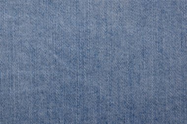 Görünür çapraz dokuması olan açık mavi bir kot kumaşın yakın çekimi. Doku tutarlı ve arka planlar için uygun..