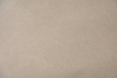 Kahverengi bir Kraft kağıt dokusunun yüksek çözünürlüklü yakın çekimi, doğal ve biraz pürüzlü bir yüzeyi var. Arkaplan olarak kullanmak için ideal