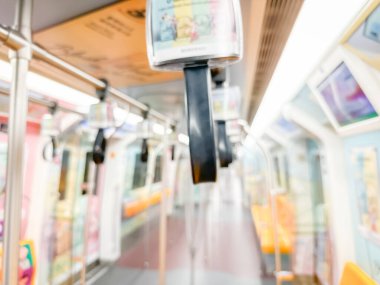 Parlak sarı koltukları ve paslanmaz çelik direkleriyle metro içi boş bir metro manzarası. Modern tren vagonu iyi ışıklandırılmış, üst kulpları ve pürüzsüz, temiz zeminleri var, hareket halindeki toplu taşımayı öneriyor..