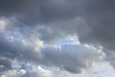 Gri ve koyu renkli bulutlarla dolu geniş bir gökyüzü görüntüsü yaklaşan bir fırtına ya da karamsar bir atmosferi işaret ediyor..