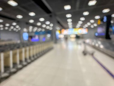 Havaalanı terminalinin bulanık görüntüsü, beklenti ve seyahat duygusunu yakalıyor. Resim boş bir bagaj teslim alanını gösteriyor