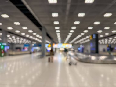 Havaalanı terminalinin bulanık görüntüsü, beklenti ve seyahat duygusunu yakalıyor. Resim boş bir bagaj teslim alanını gösteriyor