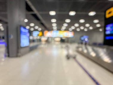 Havaalanı terminalinin bulanık görüntüsü, beklenti ve seyahat duygusunu yakalıyor. Resim boş bir bagaj teslim alanını gösteriyor