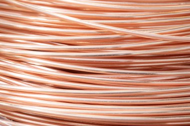 Parlak yüzeyi olan sarmalanmış bakır kabloların yakın çekimi, karmaşık örtüşen desenler, sıcak ışıklandırma..