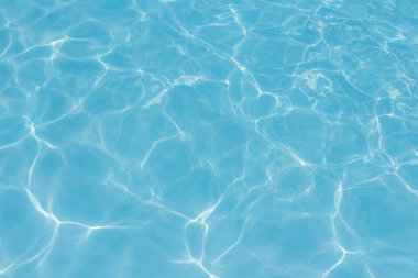 Işık yüzme havuzundaki suda maviyi yansıtıyor. Taze ve canlı görünüyor. Duvar kağıdı arka planı olarak kullanılabilir.