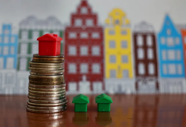 Small plastic house model on top of stacked coins. — Stock Photo, Image