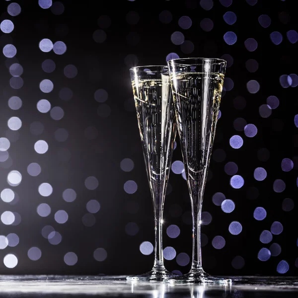 Two glasses of champagne on dark bokeh background — Stock Photo, Image