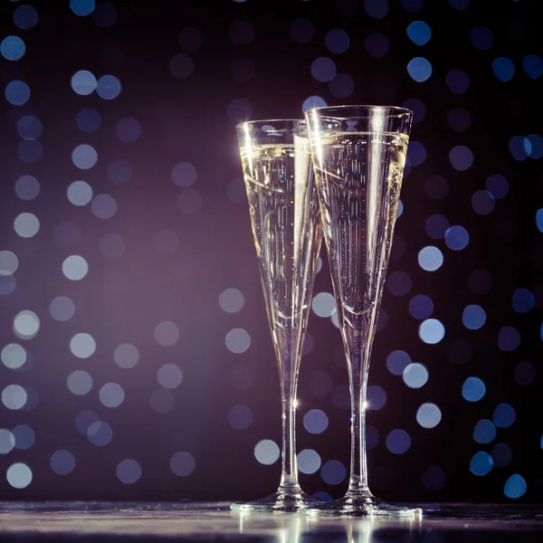 Two glasses of champagne on dark bokeh background — Stock Photo, Image