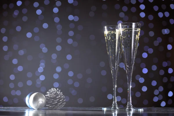 Dwie szklanki szampana z Boże Narodzenie zabawki. Świąteczne oświetlenie bok — Zdjęcie stockowe